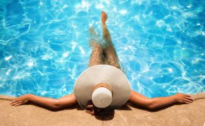 A woman relaxing in the shallow portion of a swimming pool